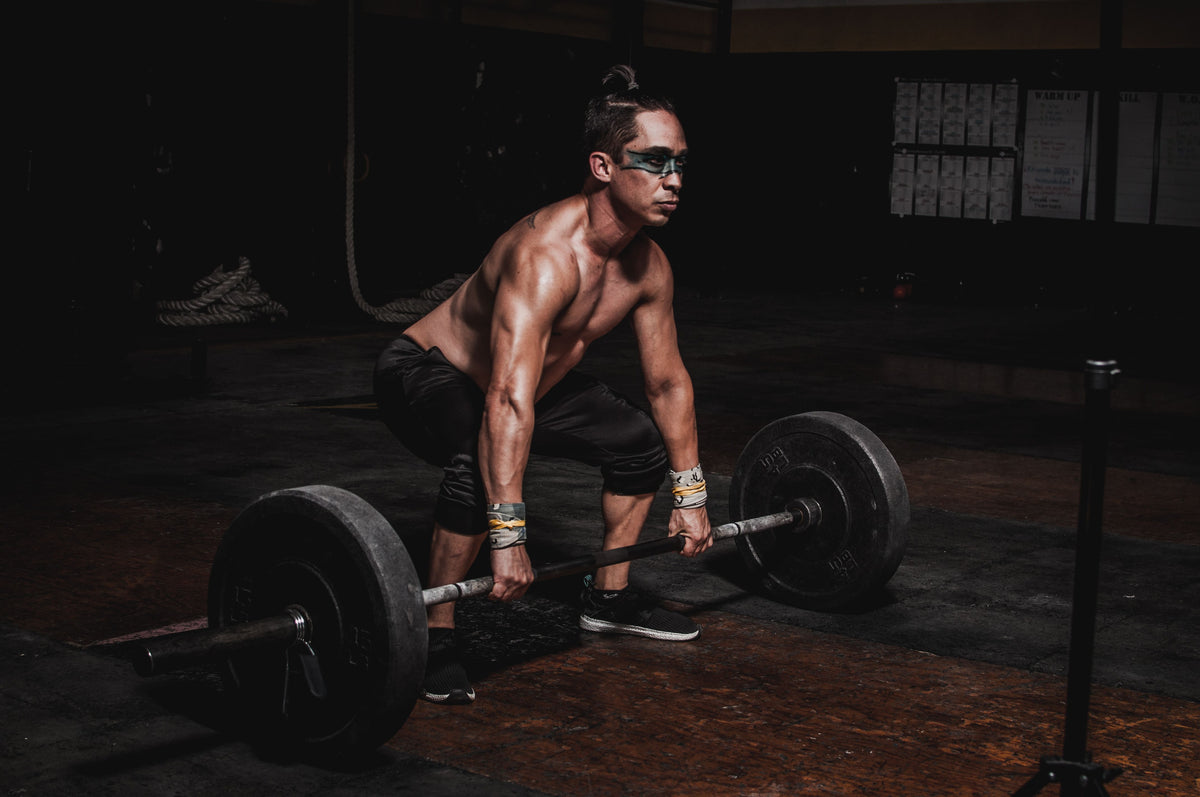 Athlete preparing a deadlift in a dark gym